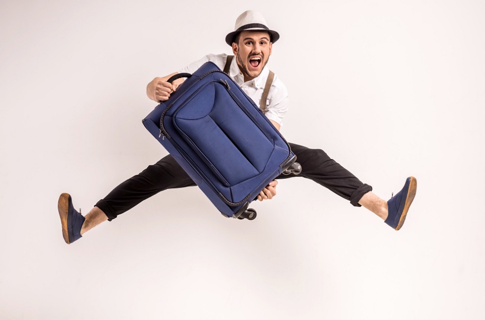Man is posing with suitcase for vacation