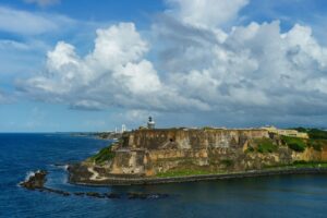 Scenic view of historic colorful puerto rico city in distance with fort in foreground from the sea (cruise ship)